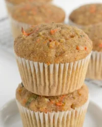 Freshly baked Zucchini Carrot Oatmeal Muffins on a cooling rack with golden raisins