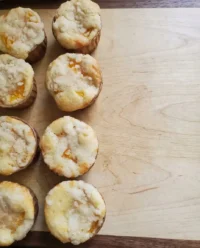 Homemade peach cobbler muffins with cinnamon topping on a wire rack