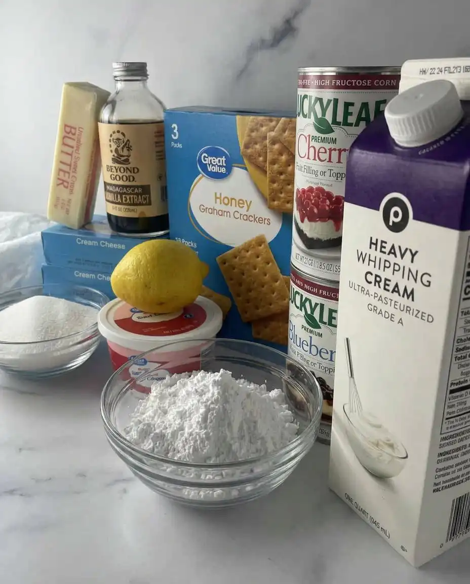 Ingredients for a no-bake cheesecake including graham crackers, cream cheese, and fruit fillings.