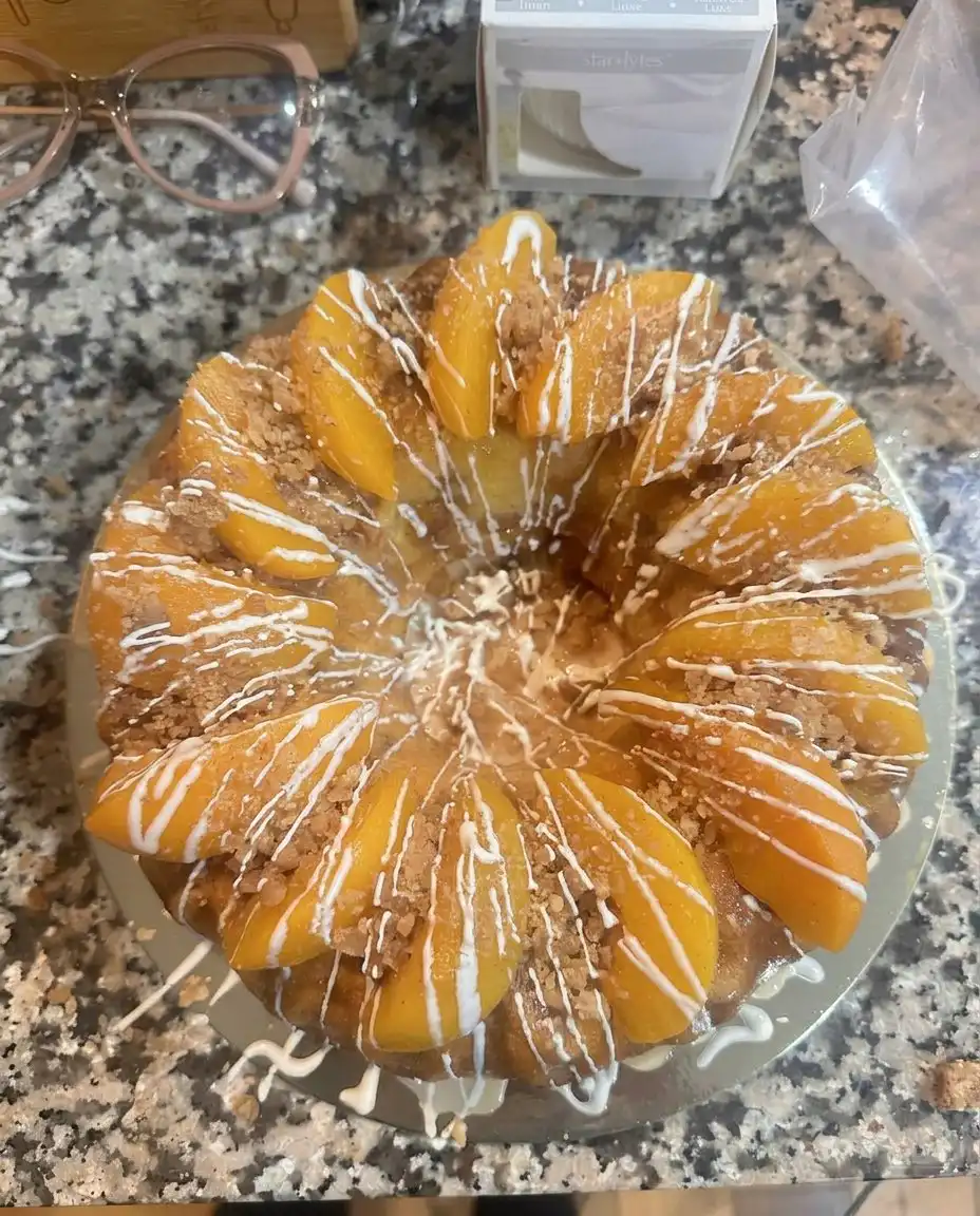 A slice of peach cobbler pound cake served with a scoop of vanilla ice cream.