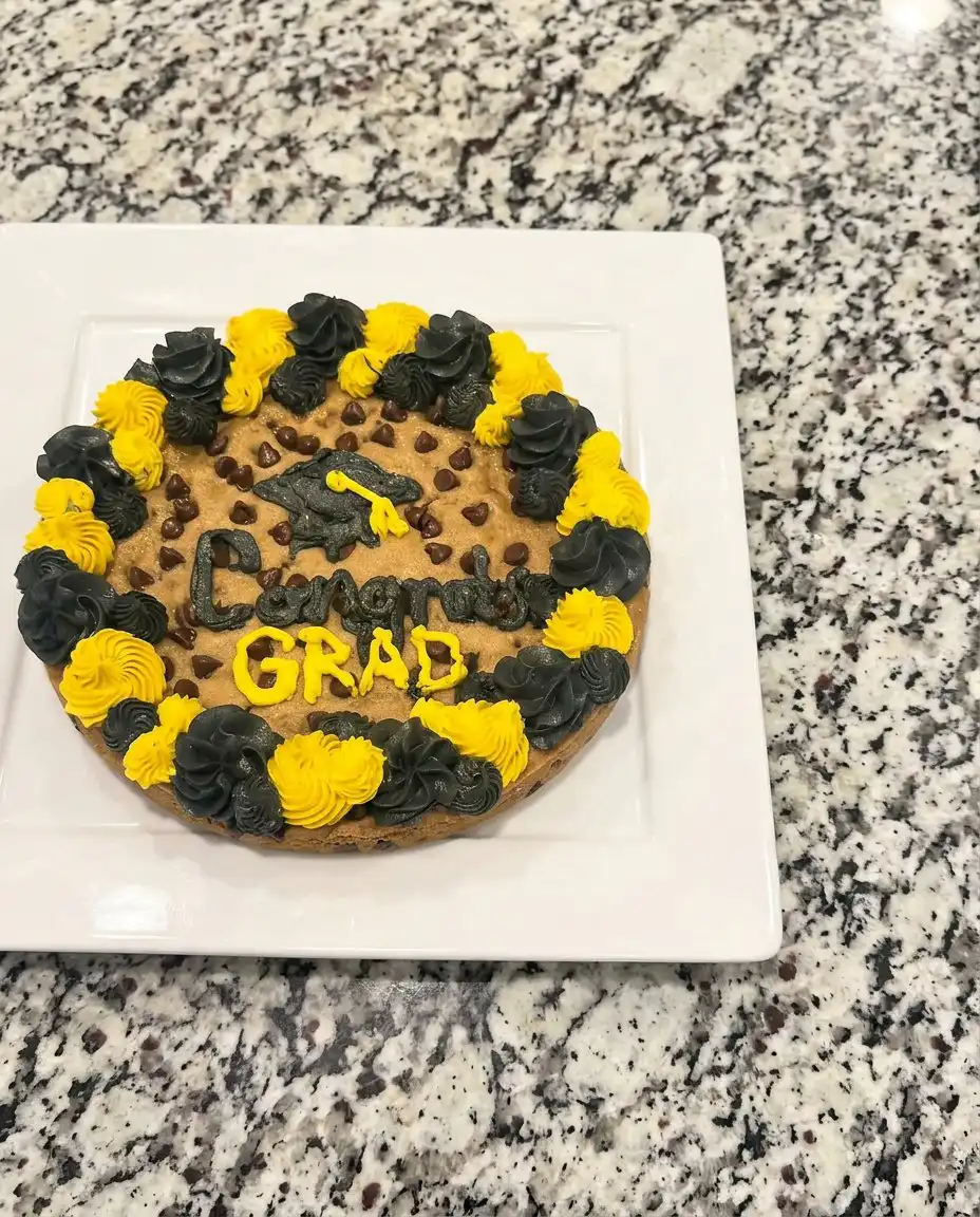 A slice of chewy cookie cake served with a scoop of vanilla ice cream