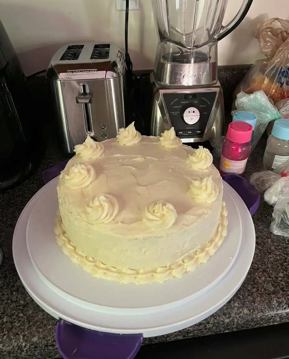 A slice of lemon velvet cake on a white plate with a fork