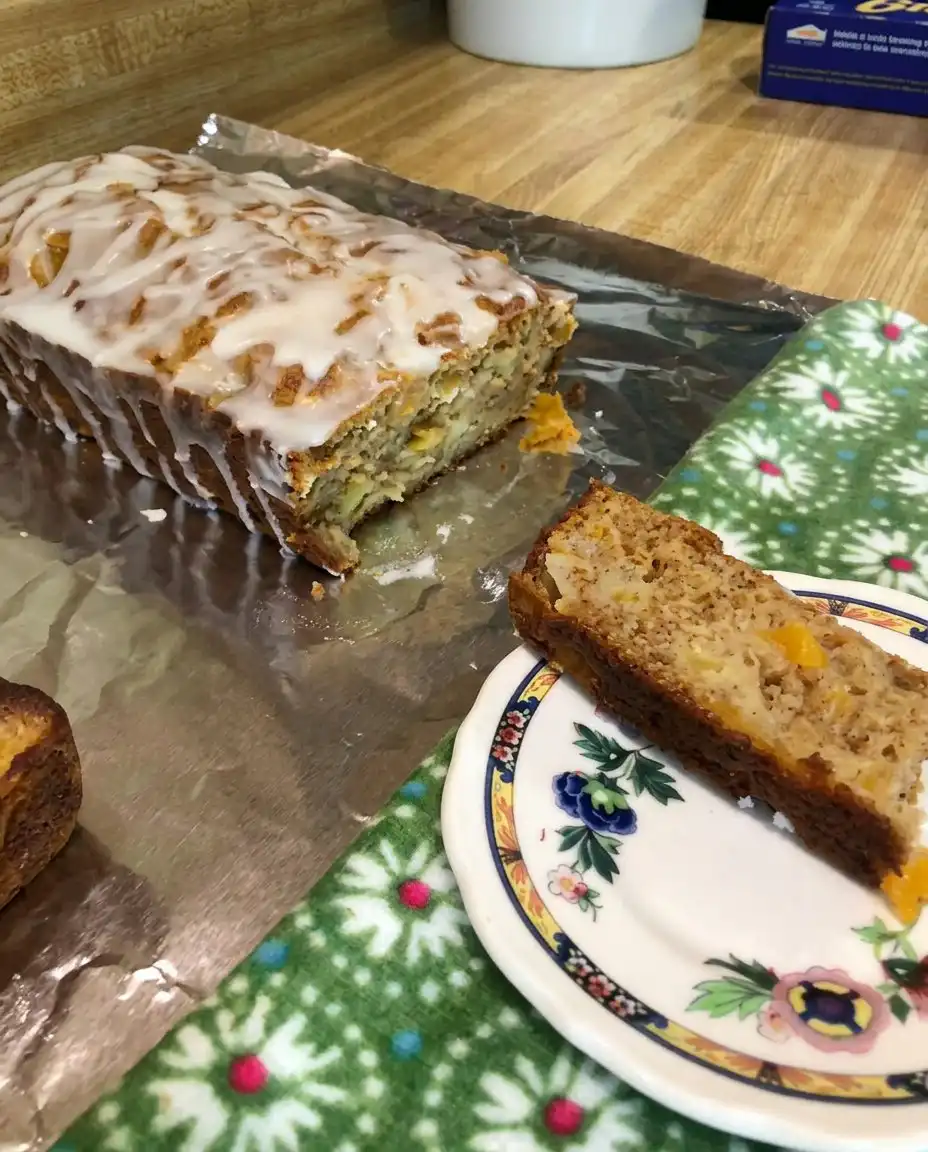 A slice of Heavenly Peach Bread next to a cup of coffee