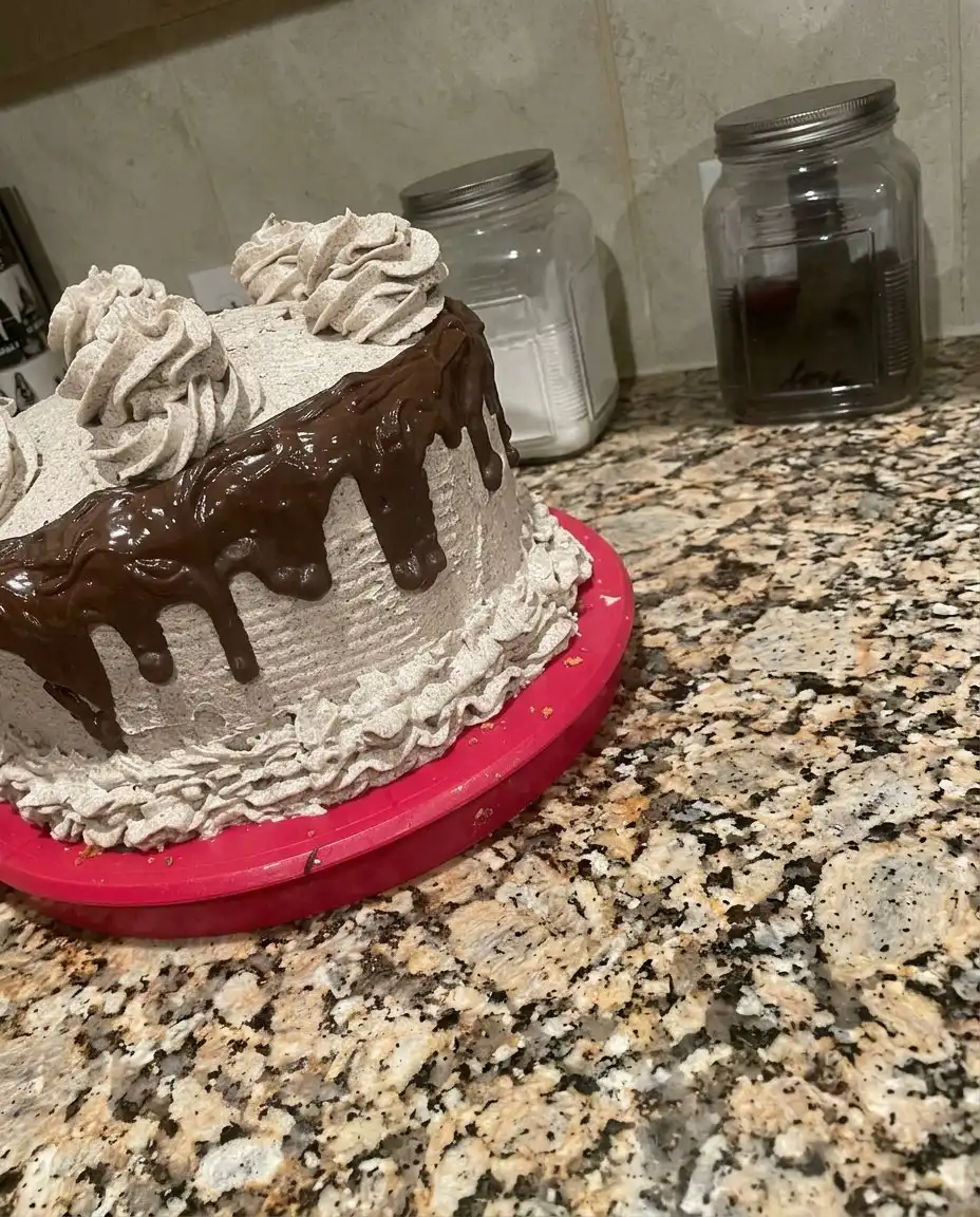A whole oreo cookies and cream cake decorated with swirls and extra cookies