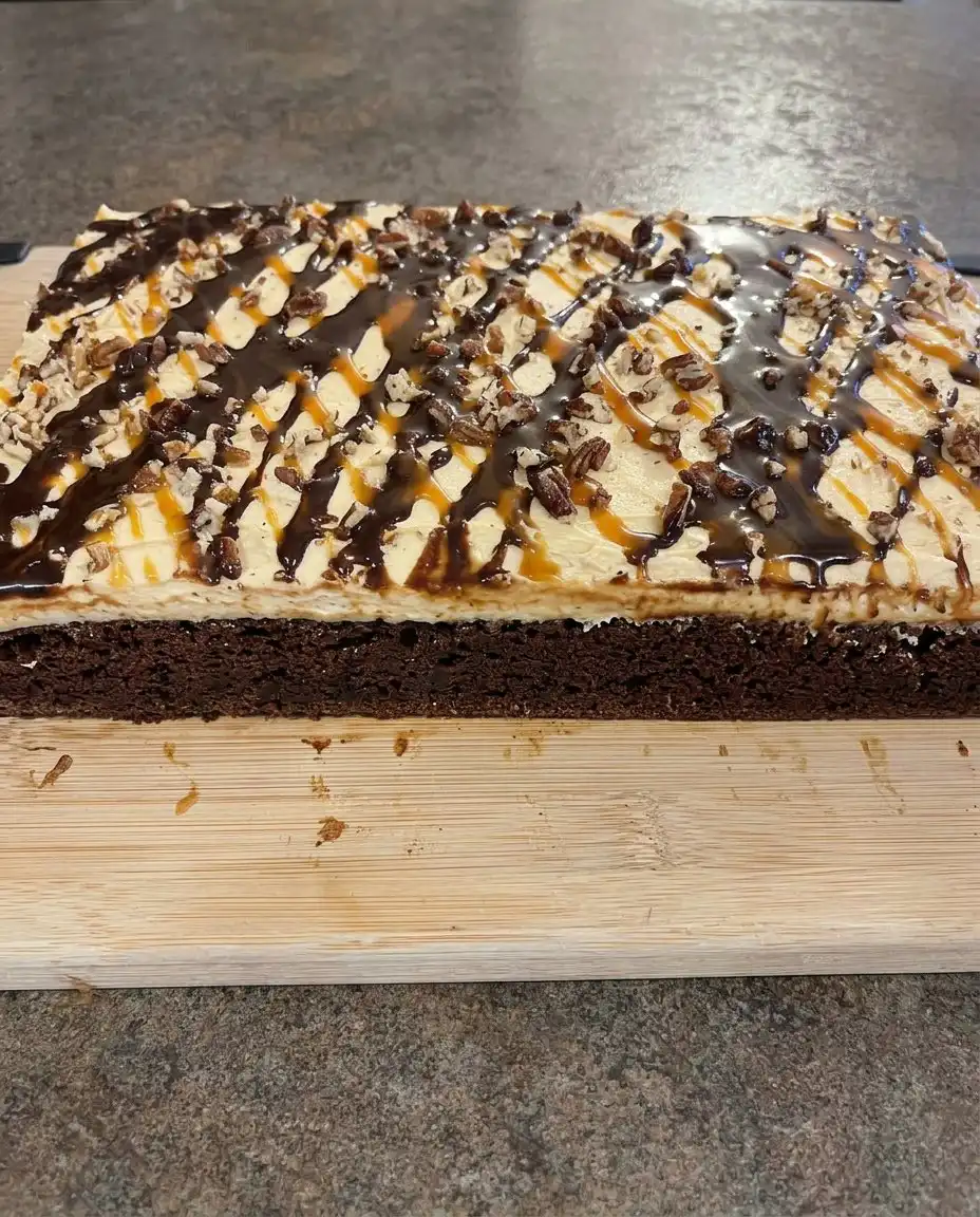 A single square slice of chocolate turtle cake showing the moist interior and caramel drizzle
