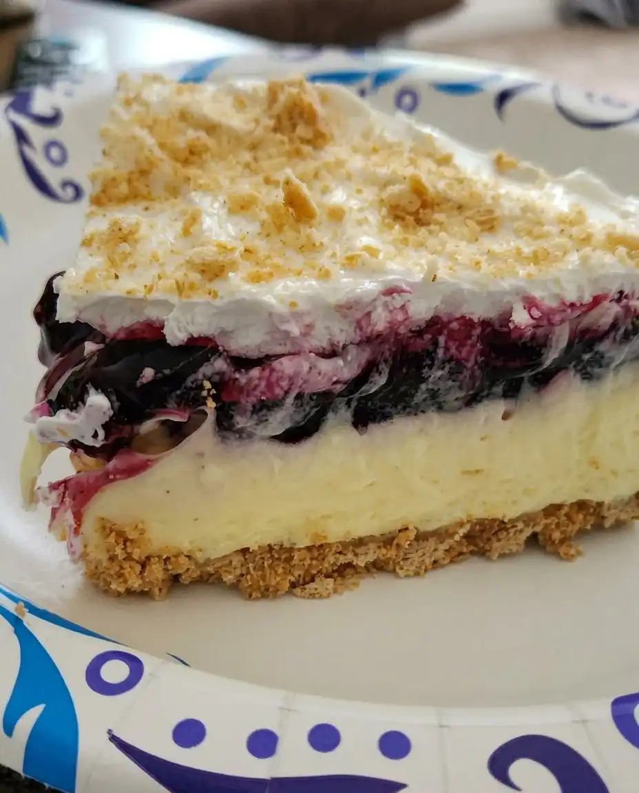 A single slice of no bake lemon blueberry dessert on a simple white plate