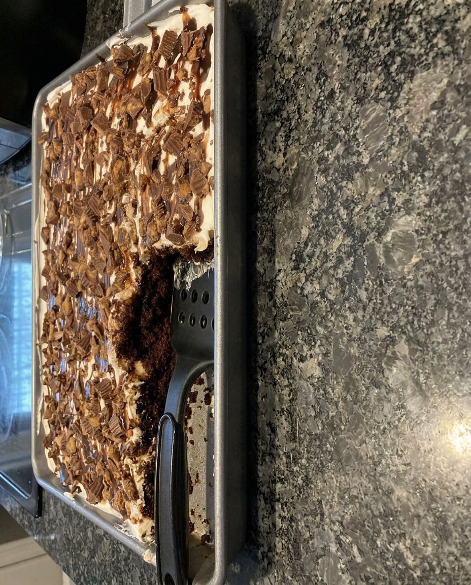 A single slice of chocolate peanut butter poke cake on a white plate