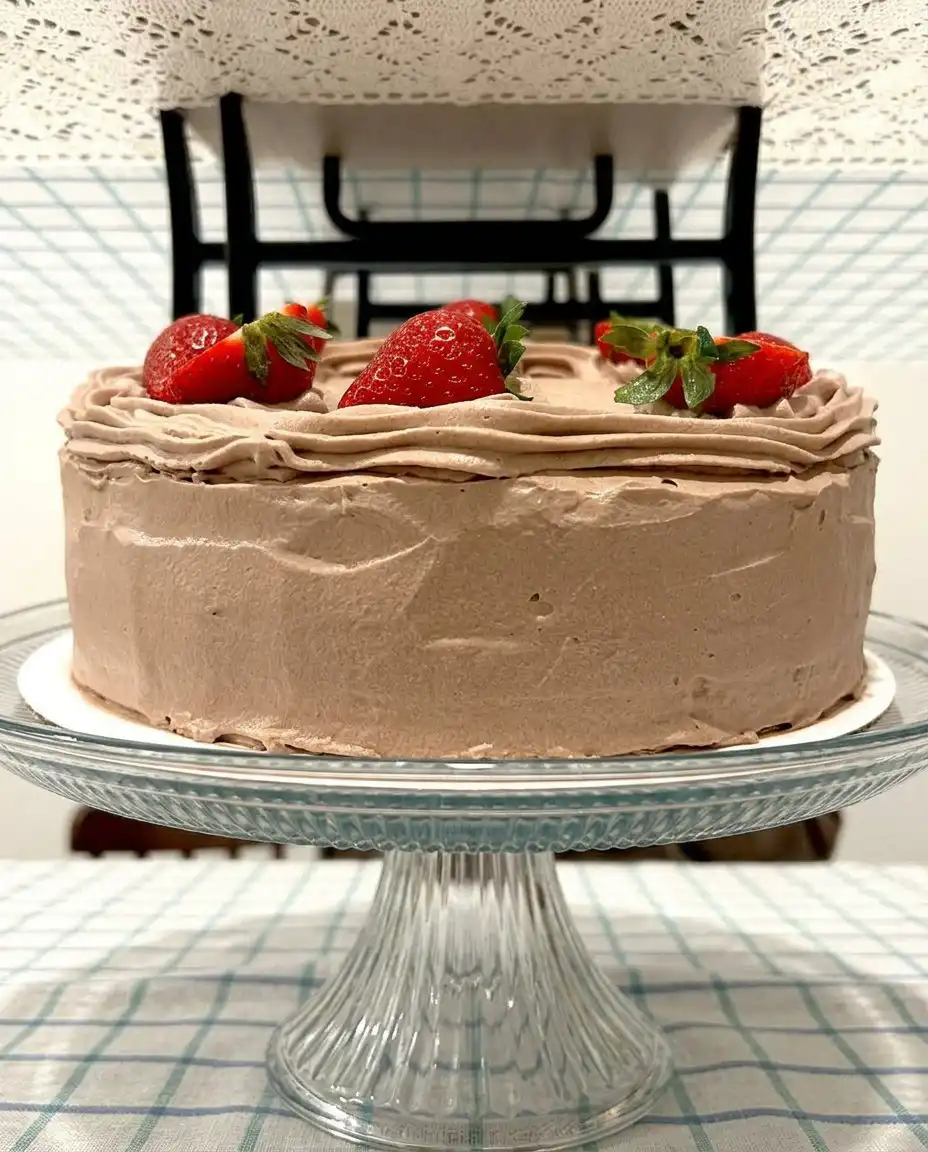 A slice of strawberry chocolate cake showing the dark layers and fruit filling.