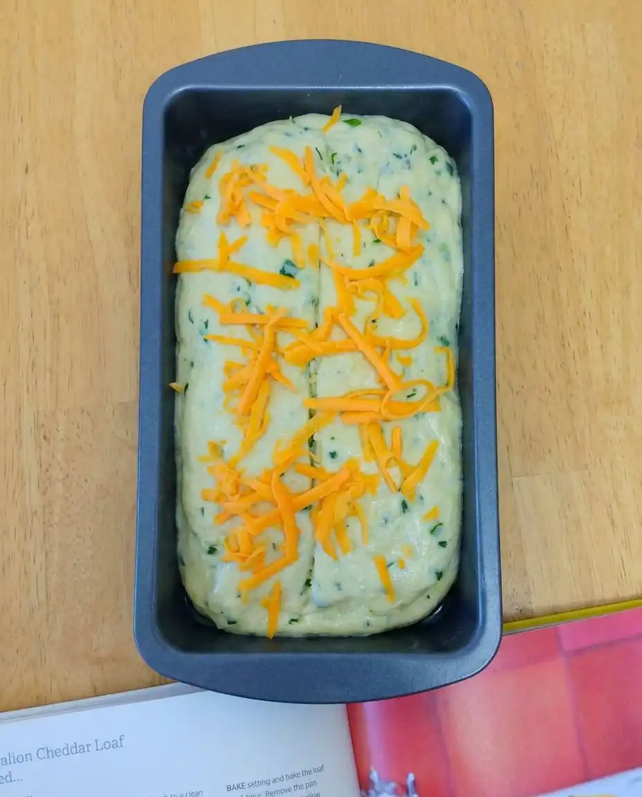 Slices of Green Onion Zucchini Cheddar Quick Bread with melting butter