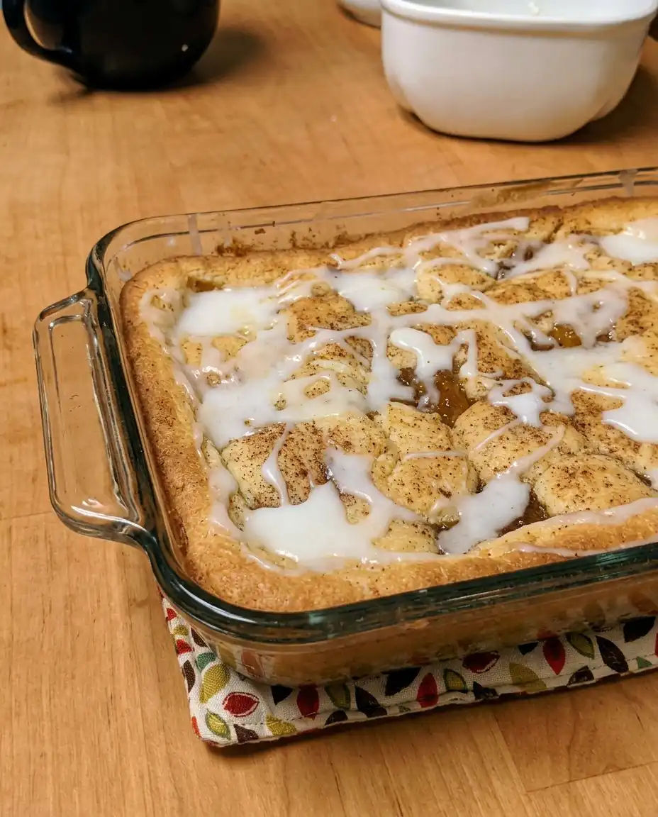 A close up of a slice of Peach Coffee Cake showing the thick layer of fruit inside.