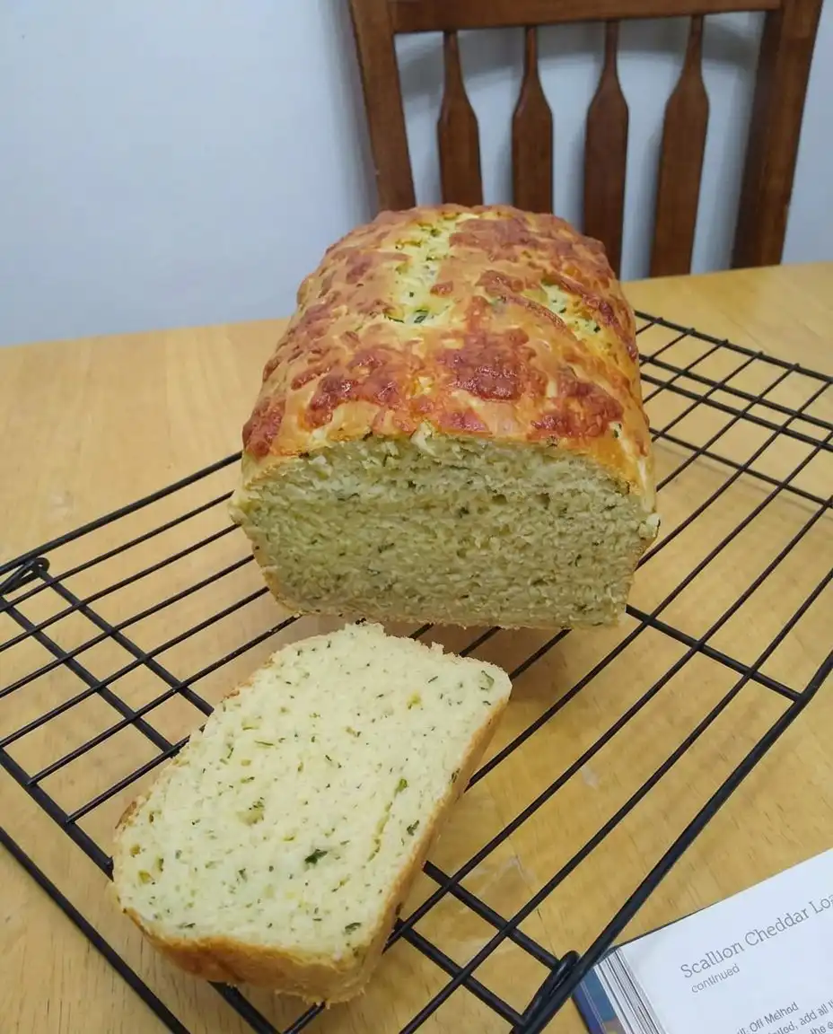 Hand squeezing shredded zucchini in a white kitchen towel