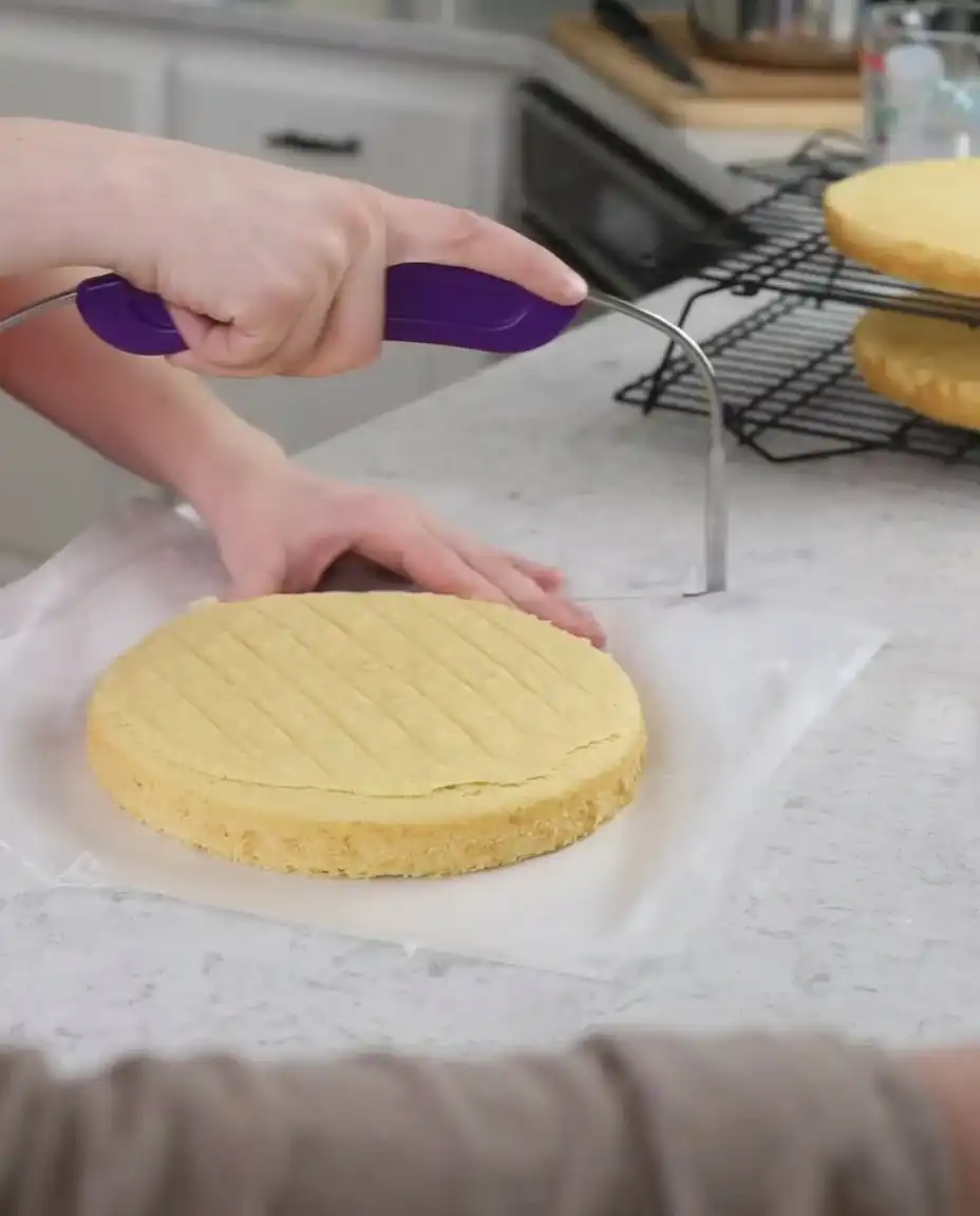 Applying whipped cream frosting to a strawberry shortcake cake