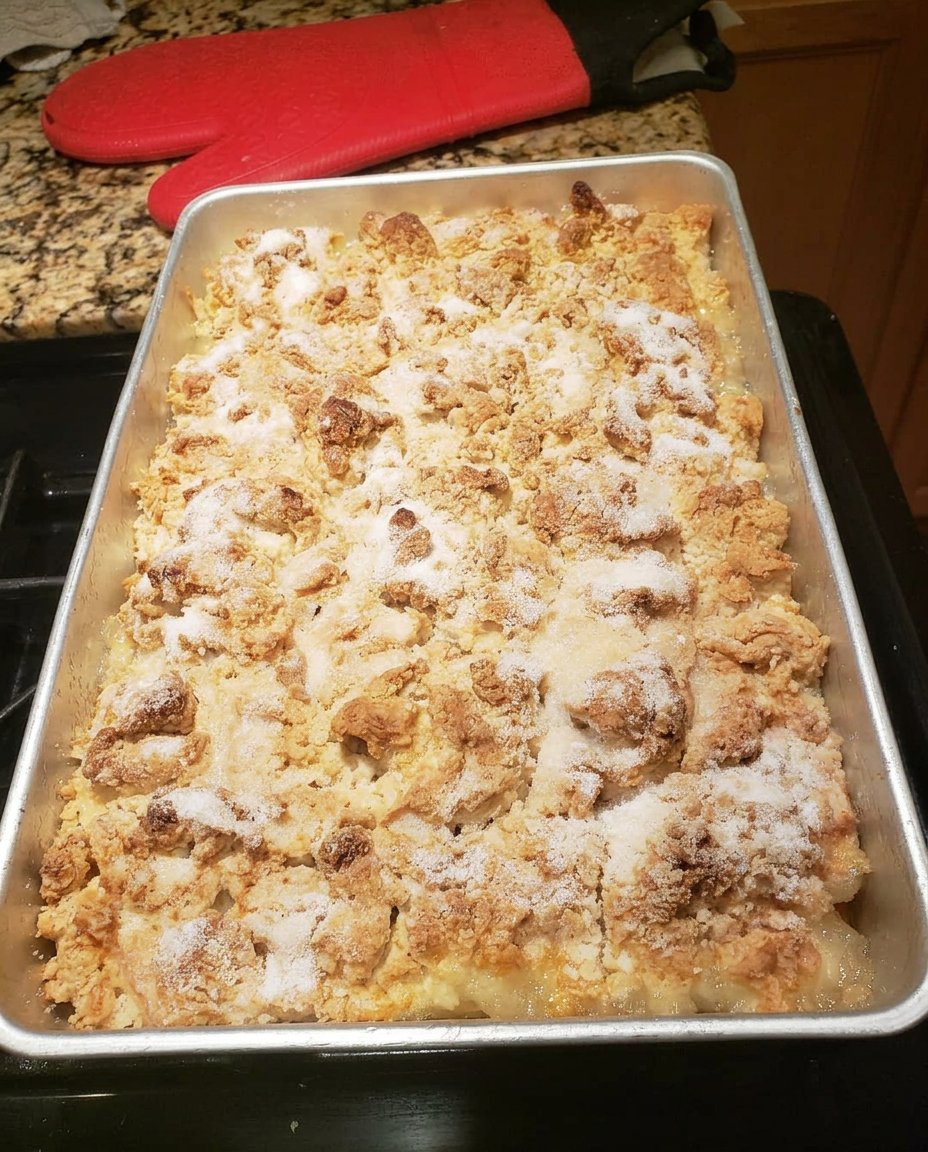 A bowl of warm peach cobbler topped with a melting scoop of vanilla ice cream
