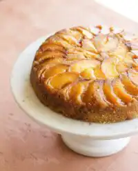 A golden brown Easy Peach Pie Filling Dump Cake bubbling in a ceramic baking dish.