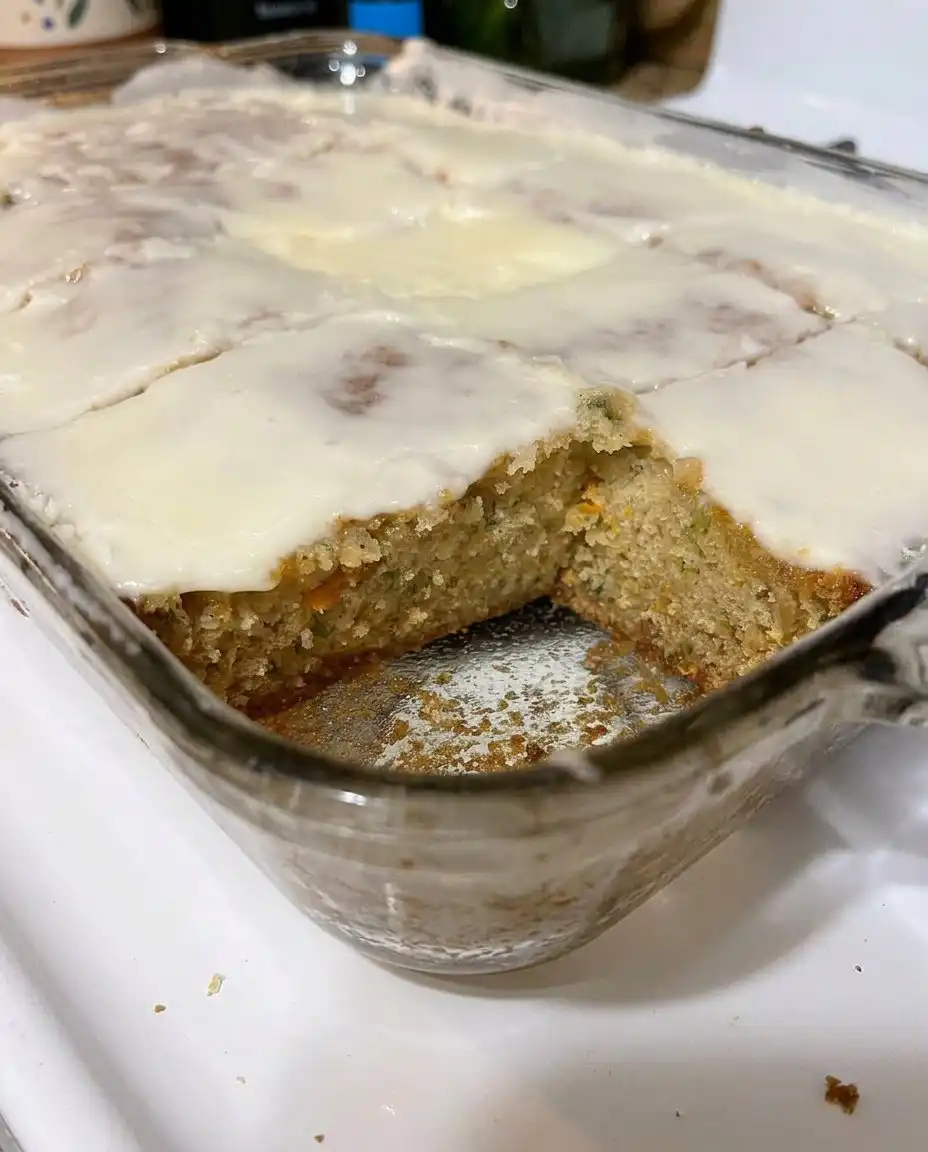 Two zucchini bars on a white plate with a fork