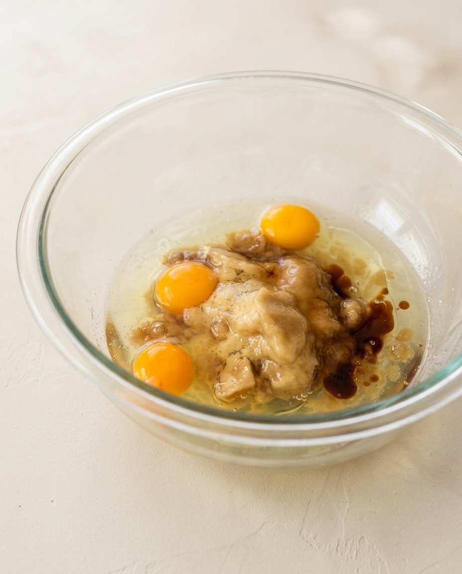 Melted butter foaming in a light colored saucepan showing brown specks.