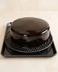 A stunning Chocolate Mirror Glaze Cake showcasing its reflective surface on a white plate