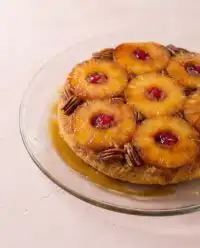 A golden Classic Pineapple Upside Down Cake cooling on a wire rack with caramelized pineapple slices.