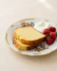 A perfect golden brown Classic Pound Cake sliced neatly on a rustic wooden cutting board
