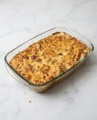 A freshly baked Classic Pumpkin Dump Cake in a vintage baking dish with a golden pecan crust.
