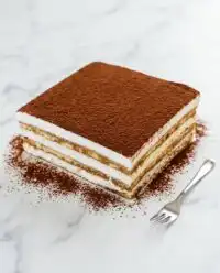 A gorgeous Classic Tiramisu Layer Cake on a beautiful display table.