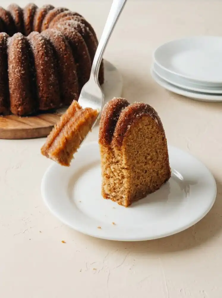 Home - Cake Savor - Savor the Simple 5 A cozy baked apple cider cake coated in cinnamon sugar sitting on a rustic metal cooling rack