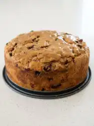 A slice of spiced Harvest Apple Cake with diced fresh apples and pecans on a rustic plate.