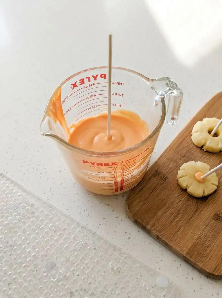Classic Pumpkin Cake Pops 15 Dipping Classic Pumpkin Cake Pops into a cup of smooth melted orange candy coating.