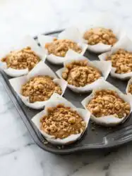 Freshly baked Classic Coffee Cake Muffins cooling on a wire rack with golden cinnamon streusel topping and vanilla glaze.