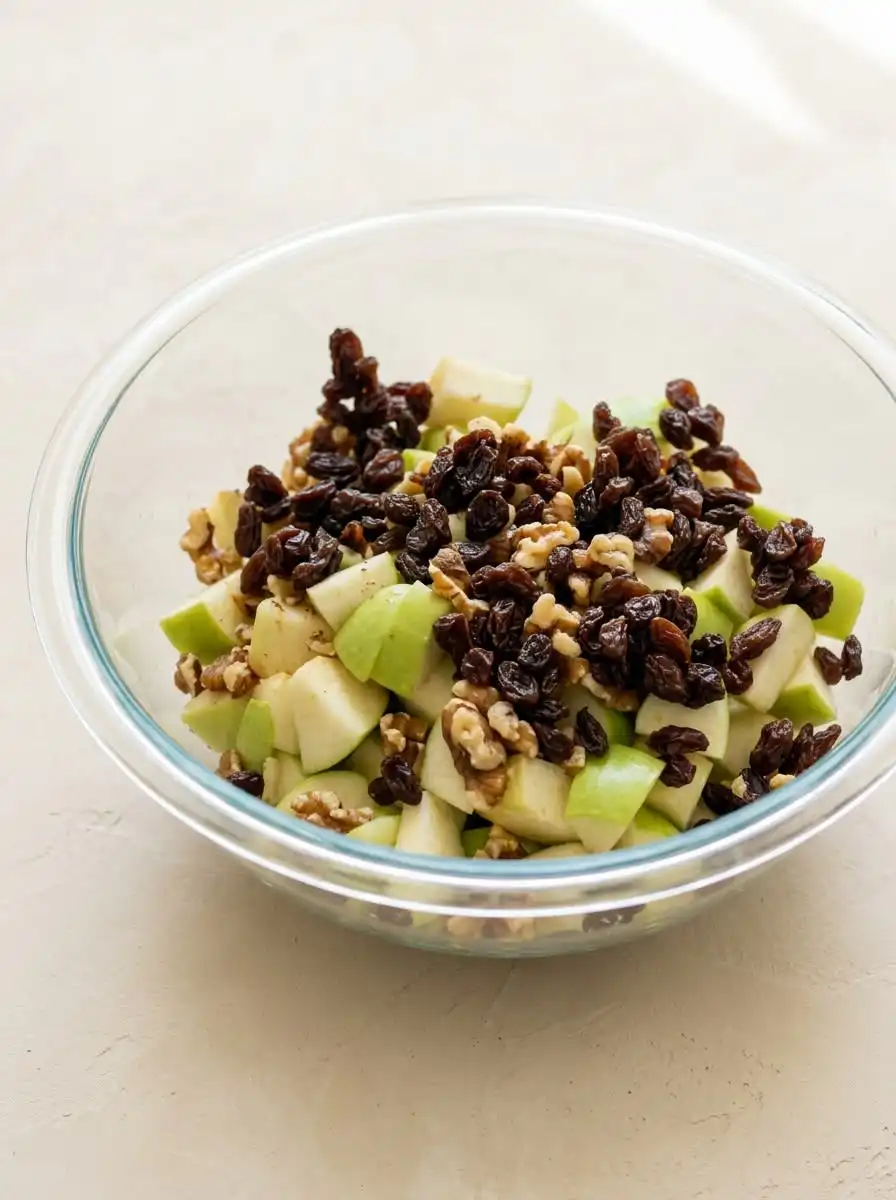 Grating whole nutmeg seed with a microplane over a bowl of Harvest Apple Cake batter.