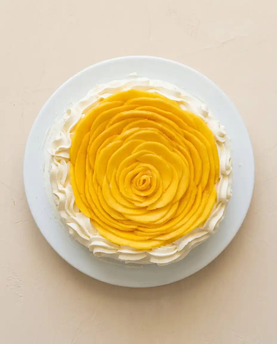 A beautiful slice of Mango Flower Crown Cake showing the inside sponge and purée layers